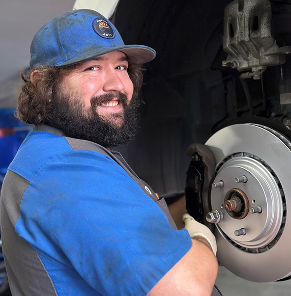 Technician smiling fixing tire disc